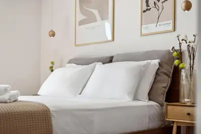 a white bed with white pillows in a bedroom at Three-Bedroom Elegant City Living in Athens