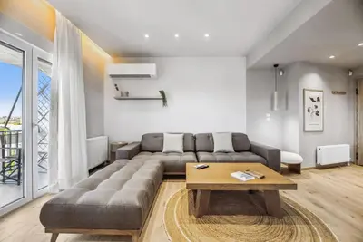 a living room with a couch and a table at Three-Bedroom Elegant City Living in Athens