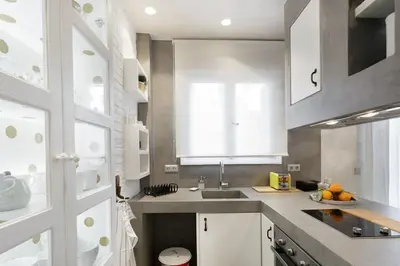 a kitchen with white cabinets and a sink at Stylish, Quiet & Relaxing, a Hidden Gem near the Acropolis in Athens