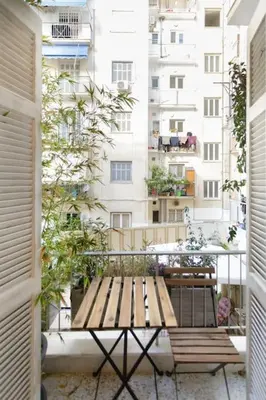 a wooden bench sitting on a balcony with a building at Stylish, Quiet & Relaxing, a Hidden Gem near the Acropolis in Athens