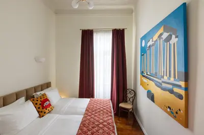 a bedroom with a bed and a painting on the wall at House of Andele in Athens