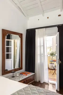 a bedroom with a mirror and a bed and a table at House of Andele in Athens