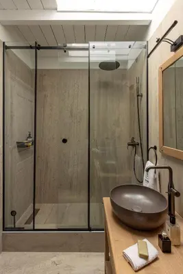 a bathroom with a glass shower with a sink at House of Andele in Athens