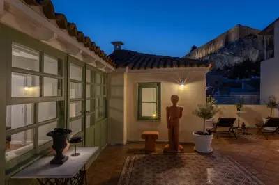 a house with a statue in a courtyard at night at House of Andele in Athens
