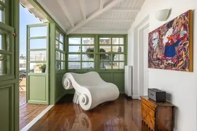 a living room with a white chair and a painting at House of Andele in Athens