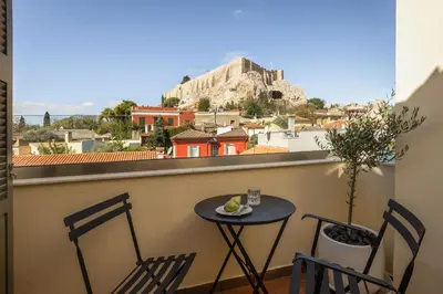 a table and chairs on a balcony with a view ofhens at House of Andele in Athens
