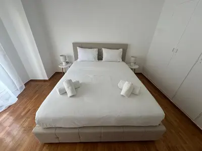 a bedroom with a large white bed with towels on it at Zografou centre apartment in Athens