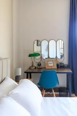 a bedroom with a table with mirrors and a blue chair at AIOLOS elegant escapes GLYFADA apartment in Athens