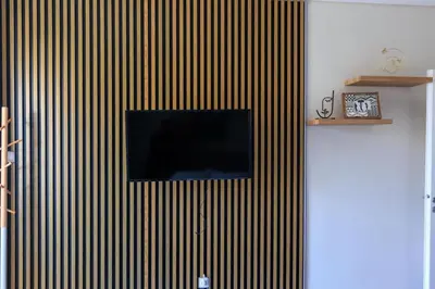 a flat screen tv on a wall with vertical stripes at AIOLOS elegant escapes GLYFADA apartment in Athens