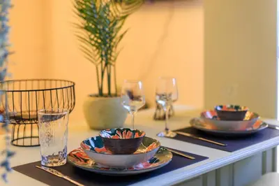 a table topped with plates and glasses and a table with plates and glasses at AIOLOS elegant escapes GLYFADA apartment in Athens
