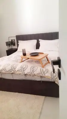 a bed with a wooden table on top of it at Penelope's in Athens