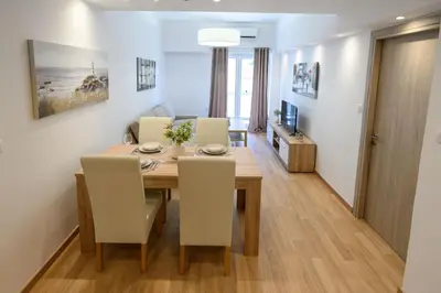 a dining room and living room with a table and chairs at 2BR Apartment next to the Metro station in Athens