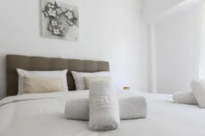 a white bed with towels on top of it at 2BR Apartment next to the Metro station in Athens