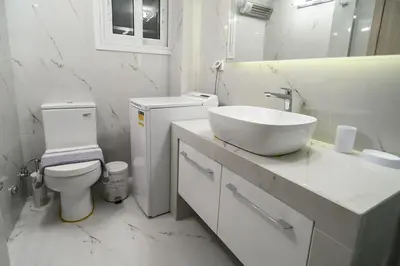 a white bathroom with a sink and a toilet at 2BR Apartment next to the Metro station in Athens