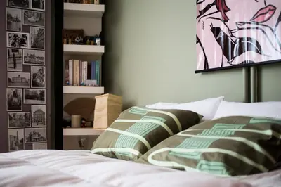 a bedroom with a bed and a book shelf at 500Mbps WiFi Budget Studio 1min from Attiki metro station in Athens