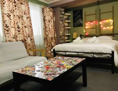 a room with two beds and a table in front of it at 500Mbps WiFi Budget Studio 1min from Attiki metro station in Athens