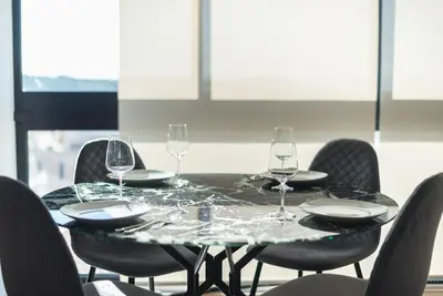 a table with four chairs and wine glasses on it at Unique Acropolis View Apartment in Athens