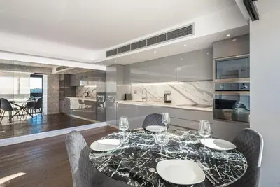 a dining room with a table and chairs and a kitchen at Unique Acropolis View Apartment in Athens