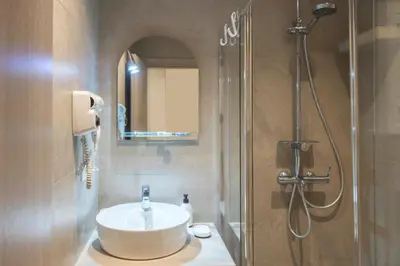 a bathroom with a sink and a shower at Koukaki Sofia's Apartment in Athens