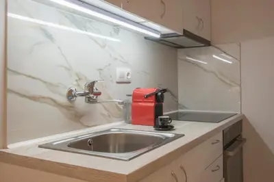 a kitchen counter with a sink and a red appliance at Koukaki Sofia's Apartment in Athens