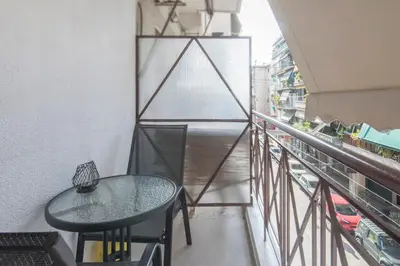 a balcony with a table and a view of a street at Koukaki Sofia's Apartment in Athens