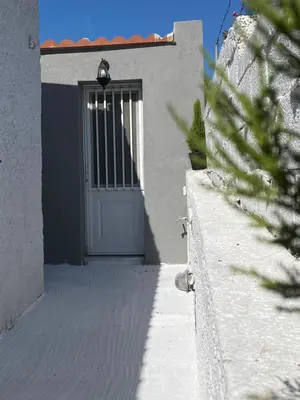 a door of a white building with a gate at Fanis Rooms in Aghia Marina