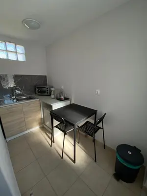 a small kitchen with a black table and two chairs at Fanis Rooms in Aghia Marina