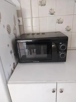 a black microwave sitting on top of a kitchen counter at LEONEG corner in Athens
