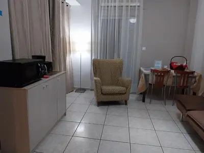 a living room with a tv and a chair and a couch at LEONEG corner in Athens