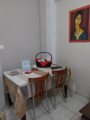 a table with two chairs and a painting on the wall at LEONEG corner in Athens
