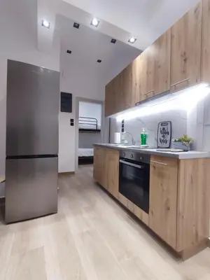 a kitchen with wooden cabinets and a stainless steel refrigerator at Harmony Twin Lofts Metaxourgeio 1 in Athens