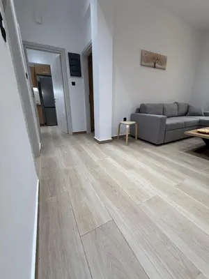 a living room with a couch and wooden floors at Harmony Twin Lofts Metaxourgeio 2 in Athens