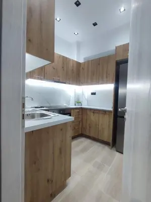 a kitchen with wooden cabinets and a stainless steel refrigerator at Harmony Twin Lofts Metaxourgeio 2 in Athens