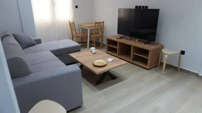 a living room with a blue couch and a tv at Harmony Twin Lofts Metaxourgeio 2 in Athens
