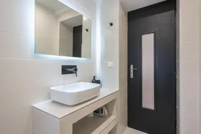 a white bathroom with a sink and a mirror at zen- open space in Athens