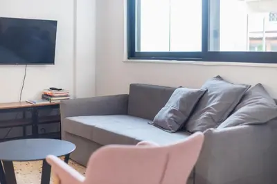 a living room with a couch and a table and a tv at zen- open space in Athens