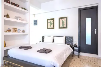 a bedroom with a white bed with a black door at zen- open space in Athens