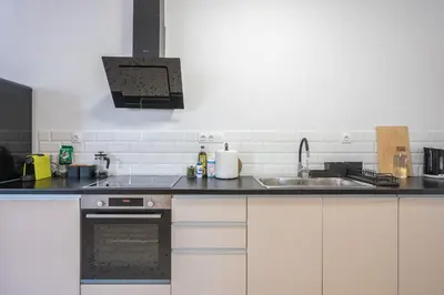 a kitchen with white cabinets and a sink at zen- open space in Athens