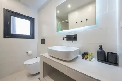 a white bathroom with a sink and a toilet at zen- open space in Athens