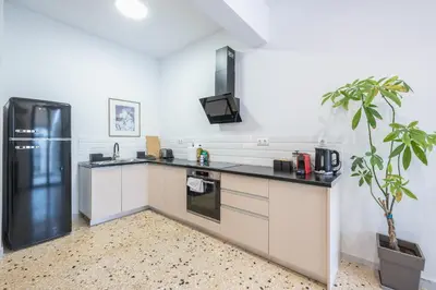 a kitchen with white cabinets and a black refrigerator at Zen Spacious, Psirri in Athens