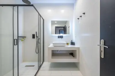 a white bathroom with a sink and a shower at Zen Spacious, Psirri in Athens