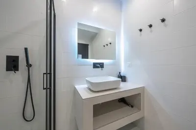 a white bathroom with a sink and a shower at Zen Spacious, Psirri in Athens