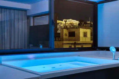 a bath tub in a room with a window at GSM Elevated Luxury Suites in Athens