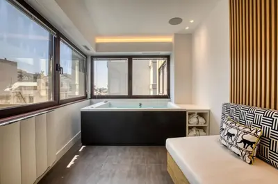 a bathroom with a tub and a window at GSM Elevated Luxury Suites in Athens