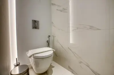 a white bathroom with a toilet and a shower at GSM Elevated Luxury Suites in Athens