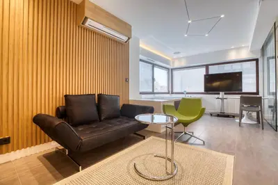 a living room with a leather couch and a table at GSM Elevated Luxury Suites in Athens