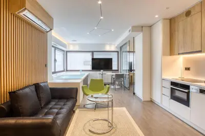 a living room with a couch and a table and a kitchen at GSM Elevated Luxury Suites in Athens