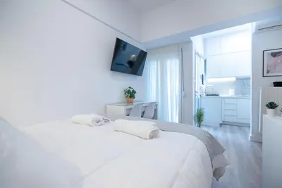 a white bedroom with a large white bed with two pillows at Stylish apartment at Exarchia in Athens