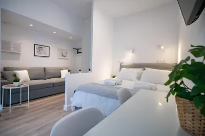 a white bedroom with a bed and a couch at Stylish apartment at Exarchia in Athens
