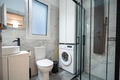 a bathroom with a toilet and a washing machine at Stylish apartment at Exarchia in Athens